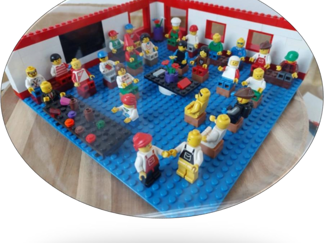 Lego minifigures sitting around a table with flowers on it